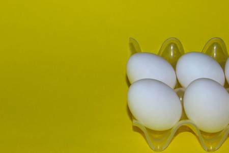 黄色背景上的白色鸡蛋。 五颜六色的食物背景。 极简主义食品复活节概念。 抽象背景。 最小的艺术设计。