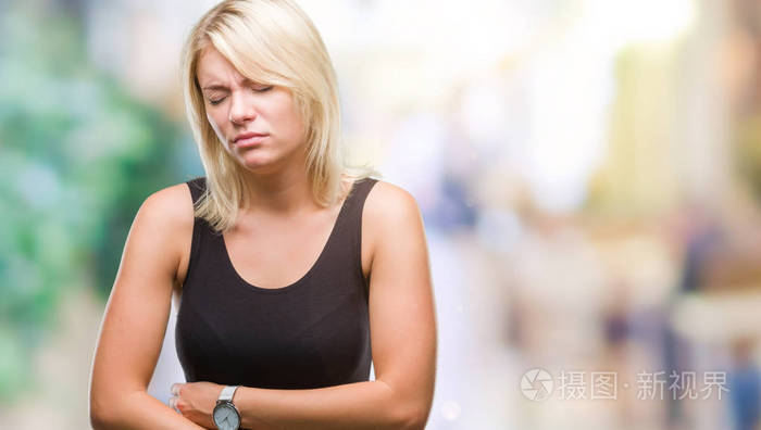 年轻漂亮的金发美女,穿着优雅的衣服,在孤立的背景上,手放在肚子上