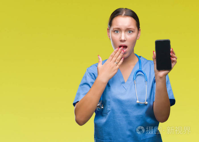 年轻的白种人医生女医生在孤立的背景上用手捂住嘴因错误地表达恐惧而