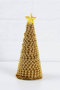 DIY金色圣诞树从珠子花环。 照片上的指南如何用你自己的手用纸板星星热胶和珠子制作一棵装饰圣诞树。 手工制作。