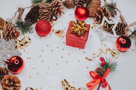 圣诞卡红色礼品盒和冷杉树枝，白色背景上有银色和红色的圆锥形和圣诞球