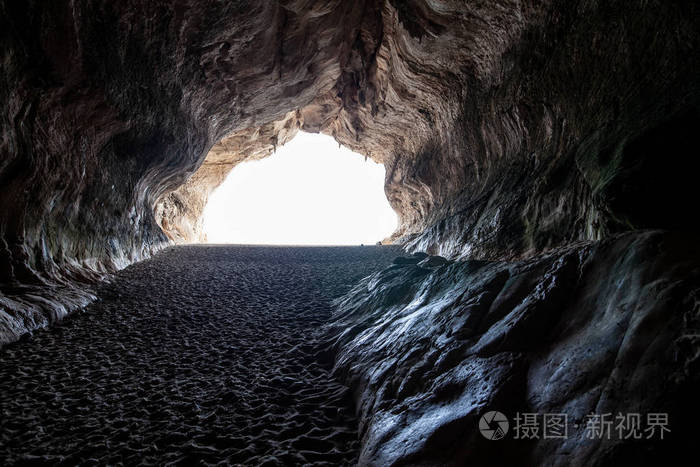 意大利撒丁岛卡拉露娜沙滩上的海洞洞穴尽头的光