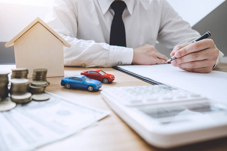 商人在做房地产投资的财务和计算成本，同时签署合同概念抵押贷款批准。