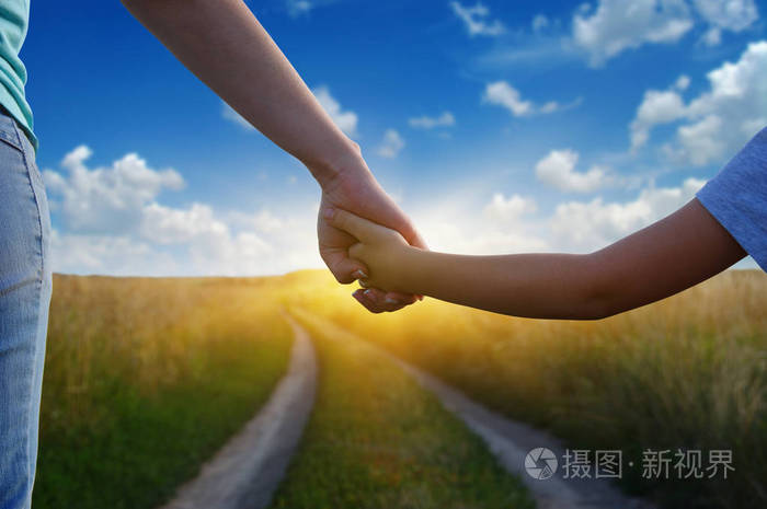 在路上和阳光下双手在田野里互相握住
