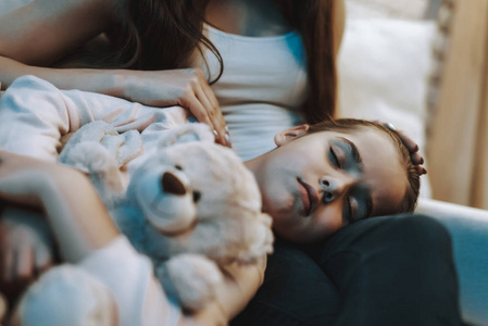 s Knees. Daughter is Holding the Teddy Bear. Mother Stroking a D