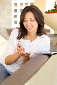 一个亚洲女人微笑着喝咖啡的肖像