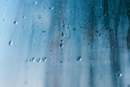 透明玻璃窗上的凝结。 水滴。 雨。 抽象背景纹理