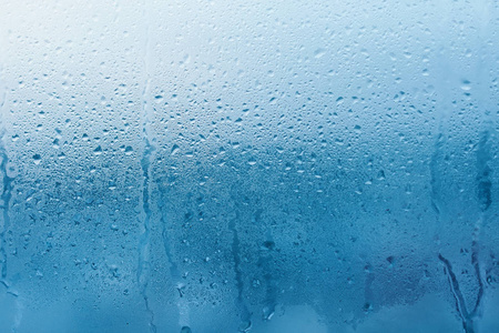 透明玻璃窗上的凝结。 水滴。 雨。 抽象背景纹理