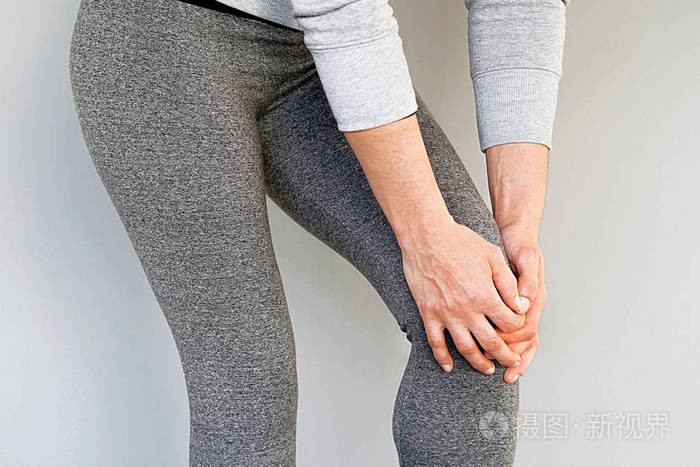 膝盖疼用痛苦的膝盖关闭女性腿女人感到关节疼痛有健康问题用手摸腿