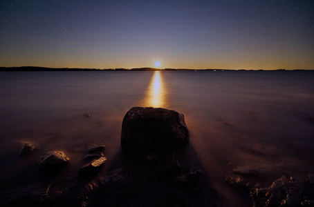 夜晚的月亮在地平线上闪耀照片