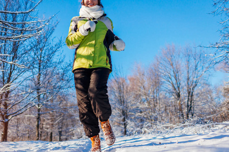 跑步运动员女子在冬林冲刺。 在寒冷的雪天在外面训练。 体育生活方式