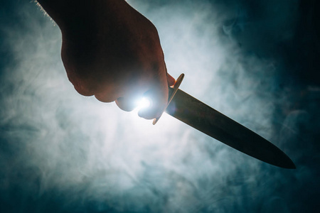 鬼武刀男性手握刀的剪影, 杀人凶手或疯子的概念照片