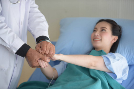 医生与年轻女性病人交谈,以监测和检查手术后.照片
