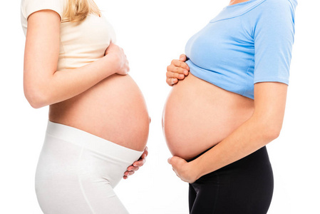 两名孕妇的侧影显示腹部在白色隔离