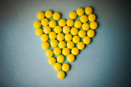 维生素抗生素小药用圆形黄色药丸, 维生素, 药物, 抗生素的形式心脏上
