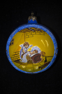 黑色背景上圣诞树的装饰品。 天使在一个黄色的圆圈里，蓝色的边框。