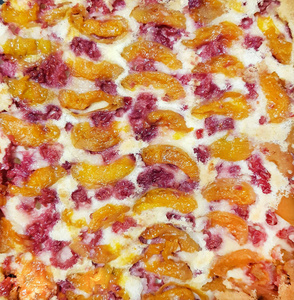 新鲜烘焙蛋糕，上面有新鲜的蔓越莓覆盆子苹果和杏