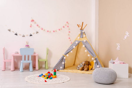 舒适的儿童房内部有游戏帐篷桌和现代装饰元素