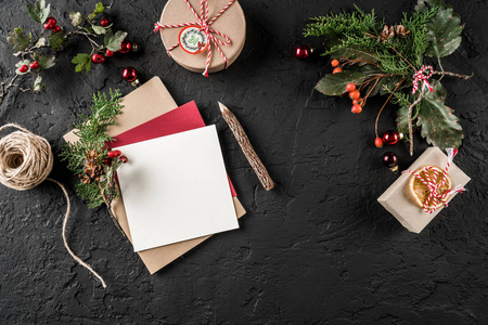 圣诞信圣诞老人在黑暗的背景与铅笔杉树枝松果礼品盒。 圣诞节和新年快乐主题。 平躺式顶部视图