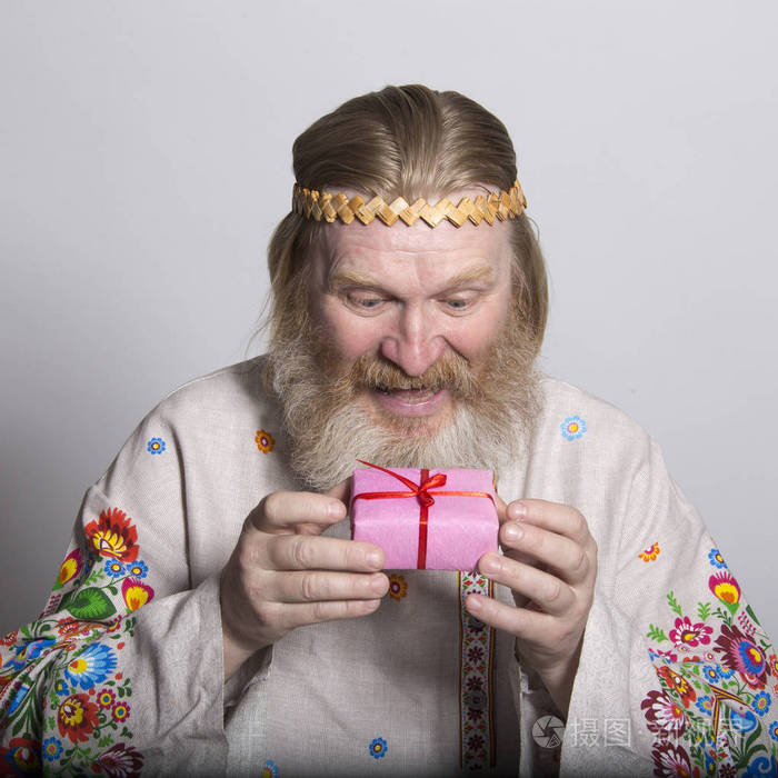 斯拉夫人穿着一件漂亮的国家彩绘衬衫,手里拿着礼物照片-正版商用图片