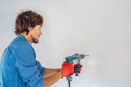 人用专业钻在混凝土墙上成孔.照片