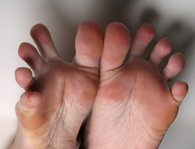 摄影棚中白色背景的成人脚特写照片