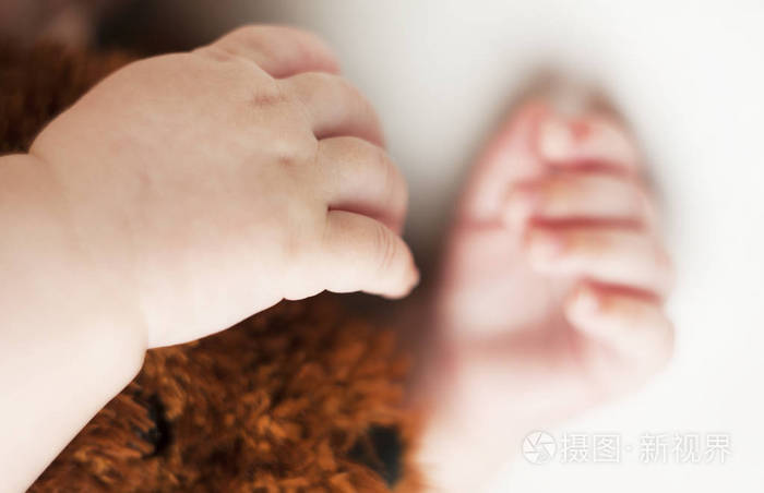 双手睡觉新生婴儿在白色背景下被隔离