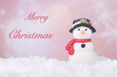 节日雪人雕像在雪地上与快乐圣诞文字在彩色背景