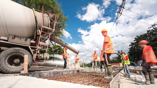 混凝土工程的道路建设与许多工人和搅拌机时间推移超移。 重建电车轨道