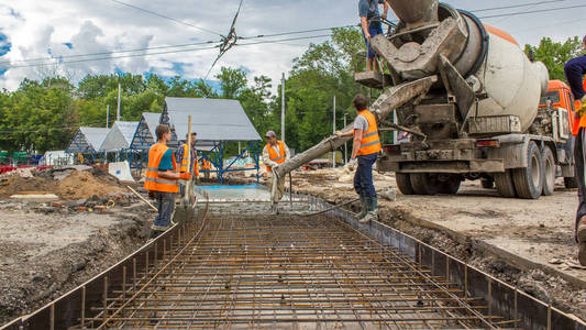 混凝土工程的道路建设，许多工人在统一挖掘机和搅拌机时间推移。 重建电车轨道