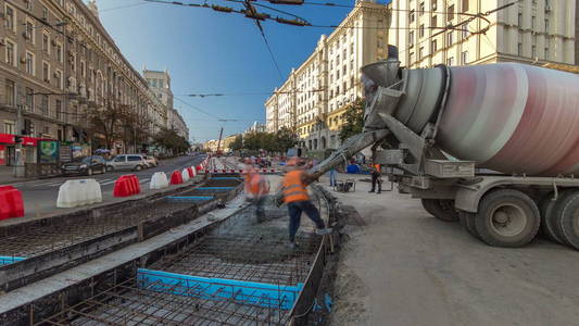 混凝土工程的道路建设，许多工人在统一和搅拌机时间推移。 重建电车轨道