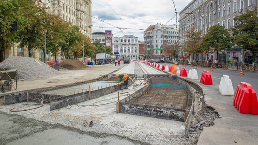 工人用防护面罩焊接加固有轨电车轨道在城市道路建设时间推移。 电车轨道的重建。