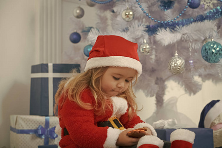 圣诞快乐的孩子与熊和礼物网络星期一。 圣诞节派对庆祝。 寒假和假期。 圣诞老人带着礼物盒的孩子黑色星期五。 新年小男孩在圣诞树上
