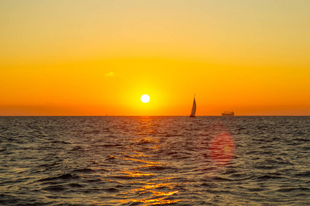 美丽的风景干净的天空日出橙色. 帆船和船在地平线上.照片