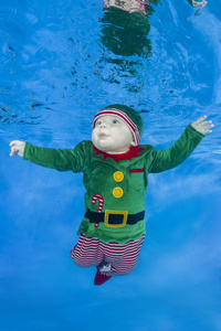 小男孩穿着蓝色的水背景下的侏儒。 健康的家庭生活方式和儿童水上运动活动。 儿童发展疾病预防