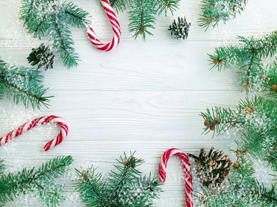 圣诞树树枝皮酮糖在白色木制背景上