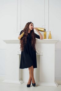 美丽女孩的时尚肖像与一瓶香槟金