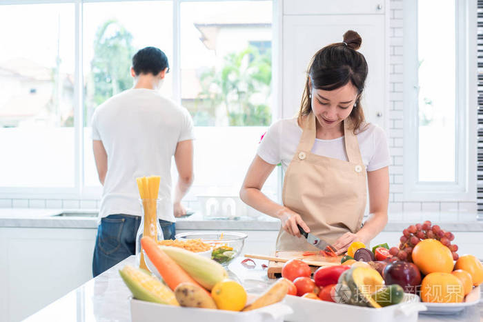 亚洲情人或夫妇在厨房里做饭和切菜. 假期和蜜月的概念.