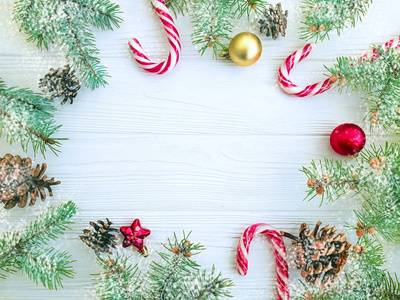 圣诞树树枝皮酮糖在白色木制背景框架雪。