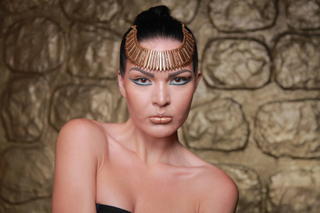 漂亮的棕褐色头发。 埃及风格丰富的豪华女人，黄金背景珠宝。