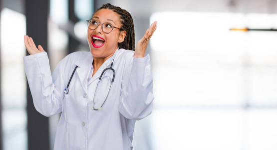 一位年轻的黑人医生的肖像，一位年轻的女医生笑着玩，快乐，感到自信和成功