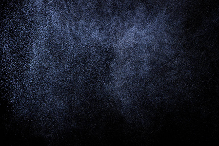 黑色背景上抽象的蓝色水溅。 白色粒子的冻结运动。 雨雪覆盖纹理。
