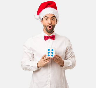 戴圣诞帽的男人拿着白色背景的骰子