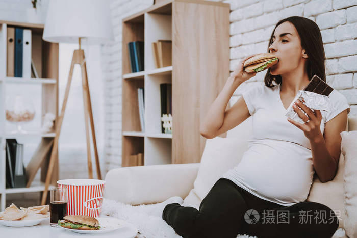 桌子上有不同的食物和可乐. 人位于家庭内部.