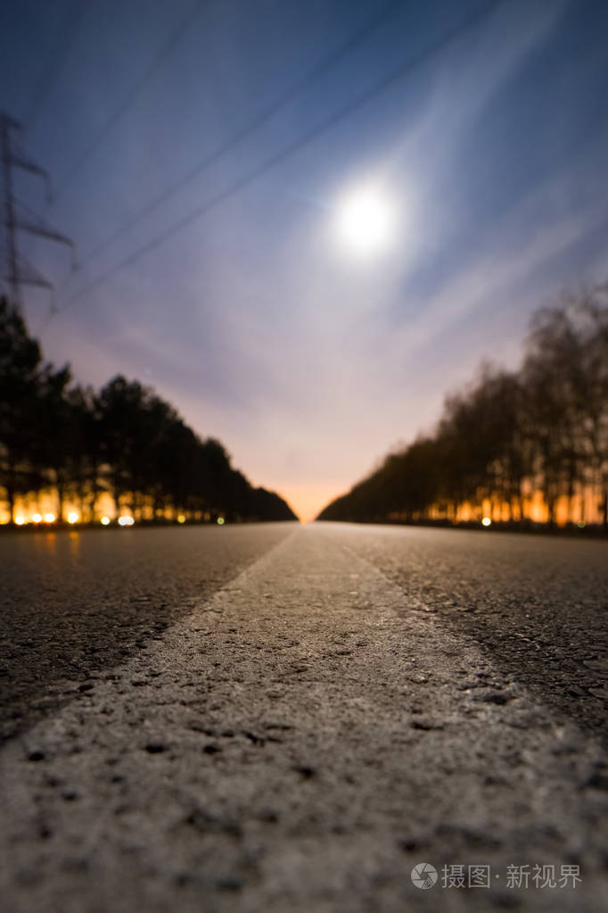 空夜柏油路 明亮的满月在云后 城市的光在道路两旁的两排树后面 照片 正版商用图片150u28 摄图新视界