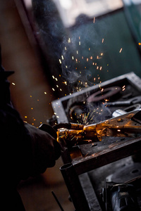 男工在修理焊机汽车排气管时戴防护手套