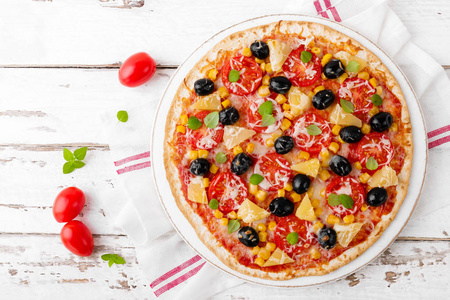 带西红柿的披萨，莫扎雷拉奶酪，橄榄，玉米和罗勒。 传统意大利菜。 顶部视图