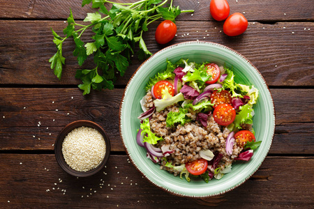 新鲜蔬菜沙拉与生菜，洋葱，西红柿和荞麦粥。 健康素食
