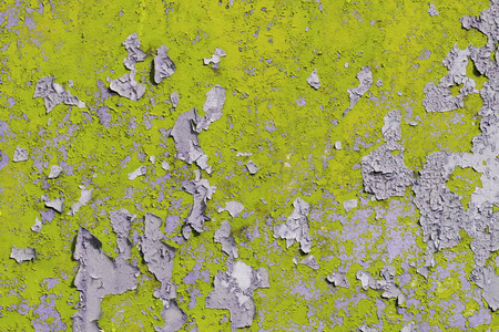 旧的粗糙混凝土表面上浅彩色黄色剥落油漆