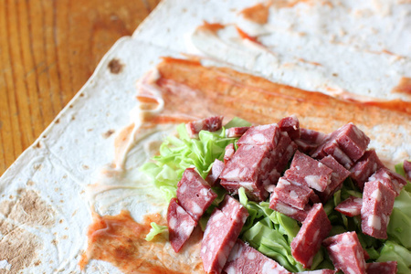 沙瓦玛的准备。 面包蛋糕里有蔬菜的肉。 快餐食品